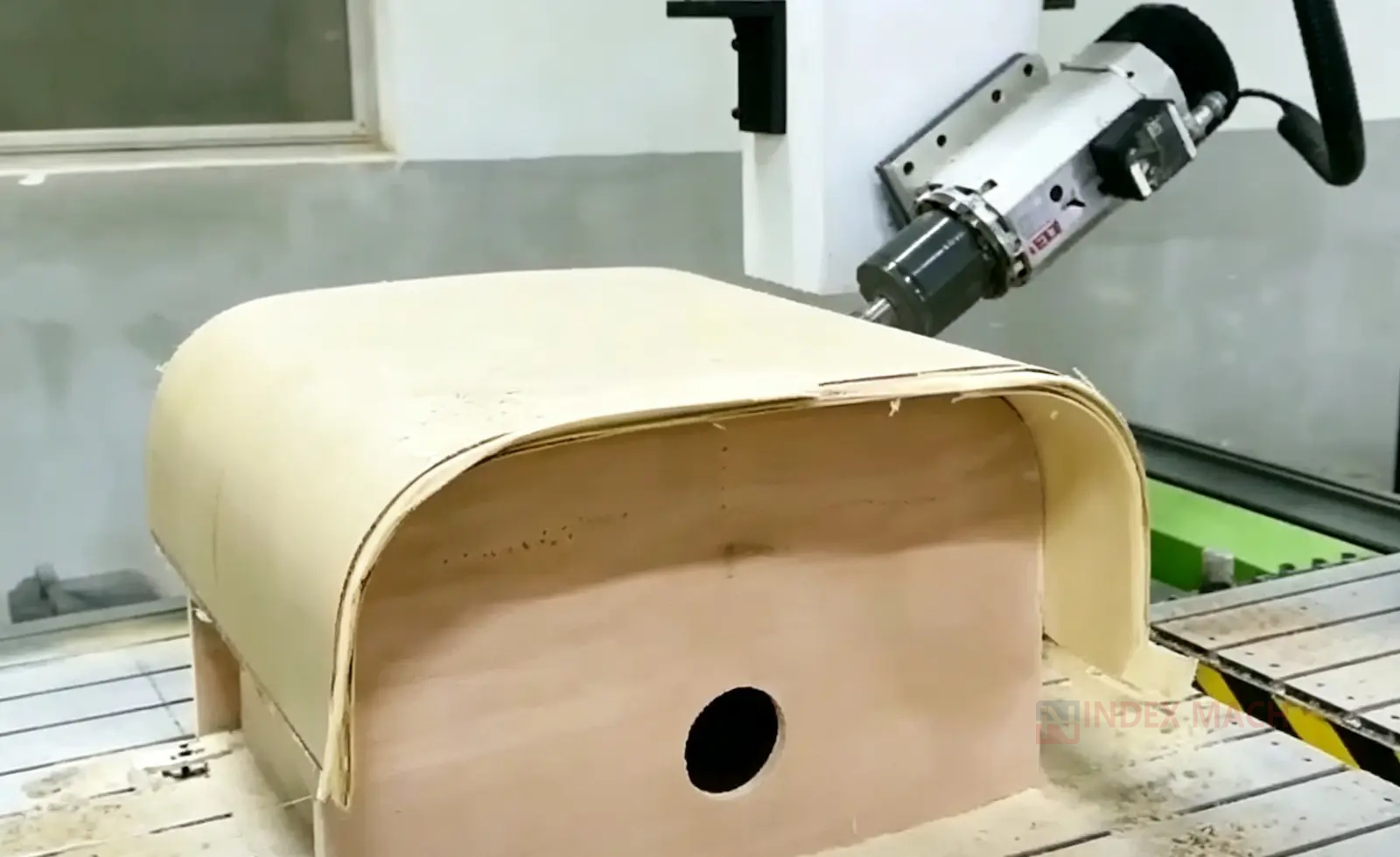 4-axis CNC router carving a curved wood surface